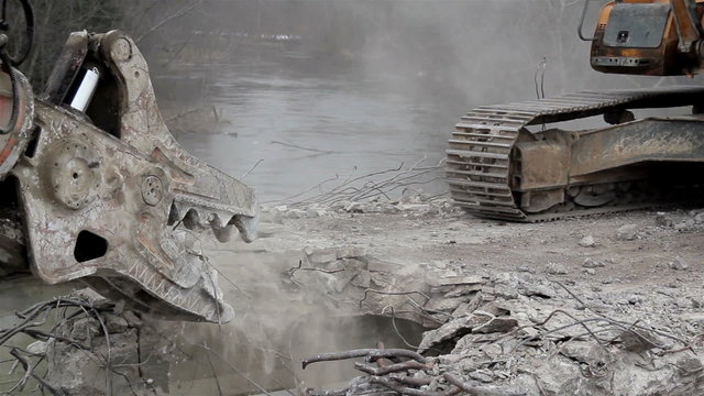 Bulldozer destroying a bridges heavy equipment with pinchers