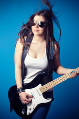 Fototapeta na wymiar beautiful young woman wearing sunglasses with guitar