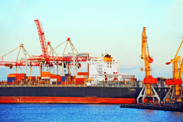 Container stack and ship under crane bridge