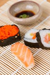 Assorted sushi with soy sauce on bamboo mat