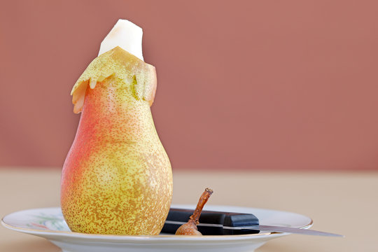 poire pel&eacute;e sur assiette avec pelure et couteau