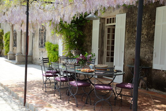 Table on the porch under blooming Wisteria