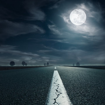 Driving on an empty highway towards the full moon