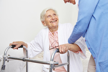 Krankenschwester hilft einer Seniorin beim Aufstehen