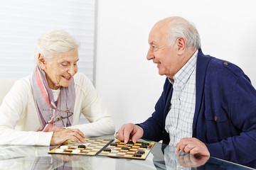 Senioren spielen Dame im Seniorenheim