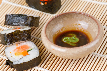 sushi and soy sauce on bamboo mat