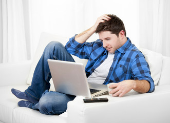 Attractive man with computer sitting on couch
