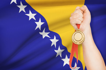 Medal in hand with flag on background - Bosnia and Herzegovina