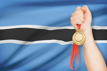 Fototapeta na wymiar Medal in hand with flag on background - Republic of Botswana