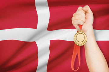 Medal in hand with flag on background - Kingdom of Denmark