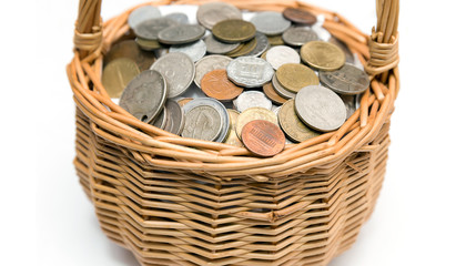 Wicker basket with coins of different countries