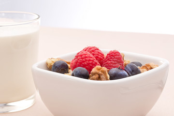 Breakfast of muesli with milk and berries