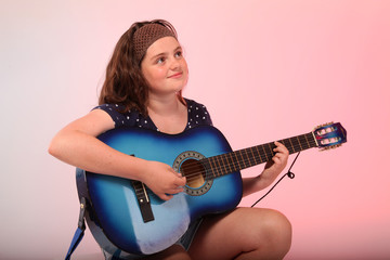 Brunette girl playing blue guitar