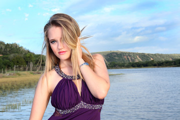 Attractive blonde lady standing on a river jetty