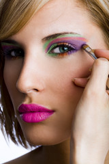 Attractive woman applying eyeshadow powder