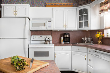 Clean white kitchen with asparagus on cutting board