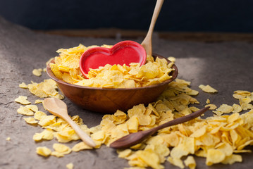 corn flakes in wooden bowl with spoons and Red heart