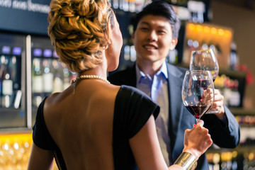 Asian couple drinking red wine
