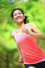 Fototapeta premium young asian woman running at tropical park 