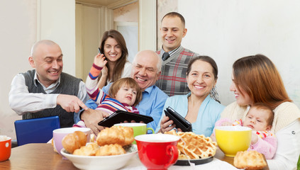 Obraz na płótnie Canvas Happy multigeneration family with electronic devices