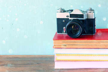 Vintage camera over stack of books - Powered by Adobe