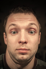 Obraz premium Shocked young Caucasian man portrait on dark background