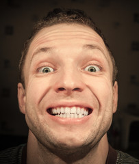 Obraz premium Young satisfied Caucasian man with wide smile. Closeup portrait