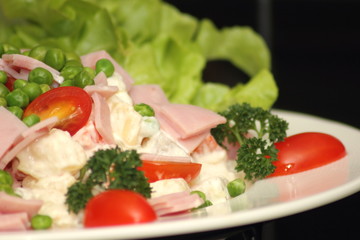 Green salad topped with sliced ham