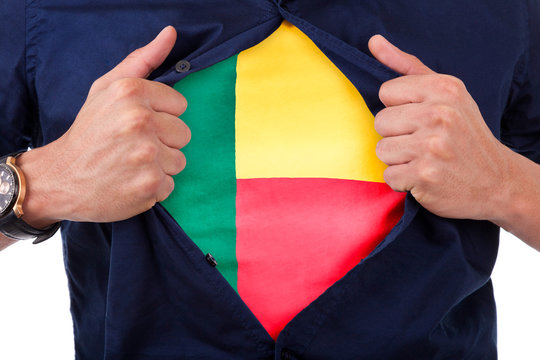 Young sport fan opening his shirt and showing the flag his count