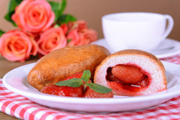 Fresh baked pasties with strawberries on plate on table
