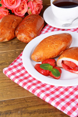 Fresh baked pasties with strawberries on plate on table