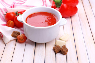 Tasty tomato soup and vegetables on wooden table