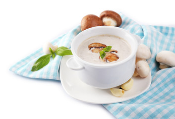 Mushroom soup in white pot, on napkin, isolated on white