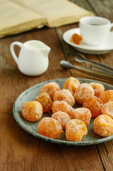 Vintage metal plate with dried kumquats on rusted wooden table