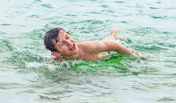 happy boy enjoys crawling in the ocean