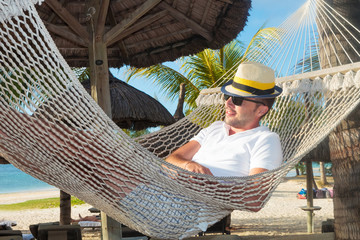 Fototapeta relaxed man in a hammock on the beach obraz