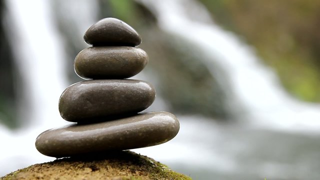 Stacked zen stones and waterfall