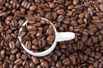 Espressotasse steht zwischen vielen Kaffeebohnen