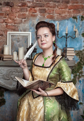 Beautiful woman in medieval dress writing in diary
