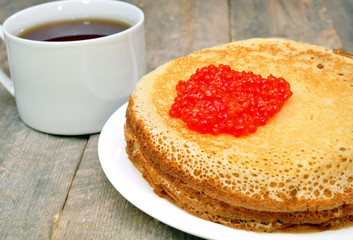 pancakes with red caviar and a cup of tea