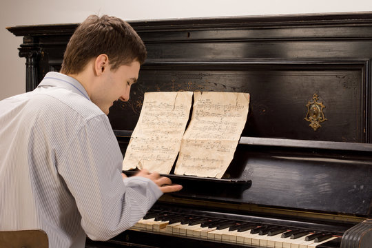 Young man smiling as he plays the piano