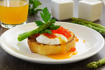 Fresh toast with poached egg, caviar and asparagus.