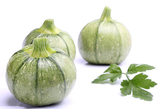 Round zucchini with parsley isolated on white
