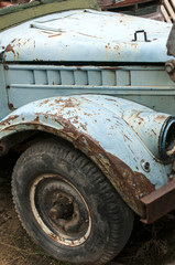 Wheel, rusty mud-guard and car hood of vintage car