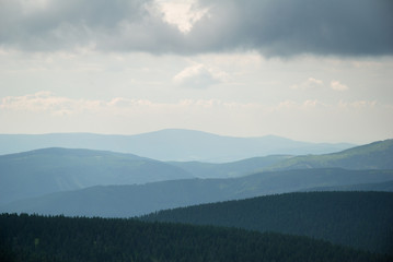 Hills and valleys under cloudy sky