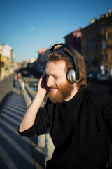 young stylish bearded man listening to music