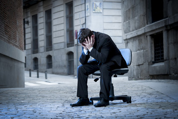 Business Man sitting on Office Chair on Street in stress