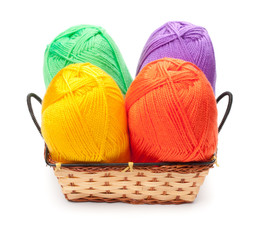 four yarn skeins in yellow, orange, green, purple colors in bask