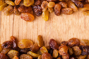 Diet healthy food. Border of raisin on wooden background