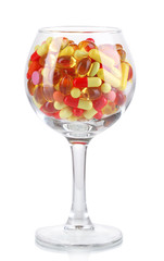 Goblet with pills isolated on white